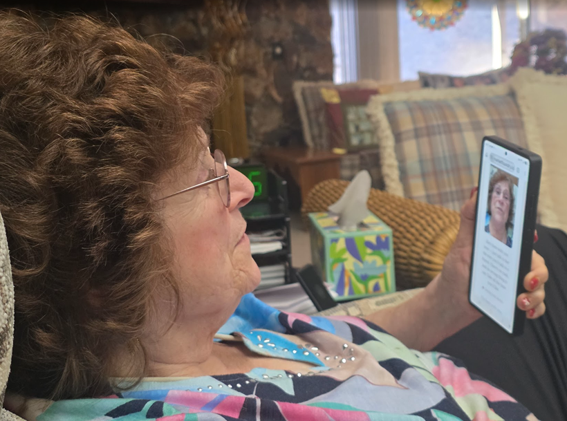 A storyteller at home, mid story, phone in hand